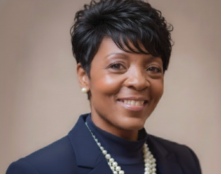 Group of young students reviewing documents outside a university building.